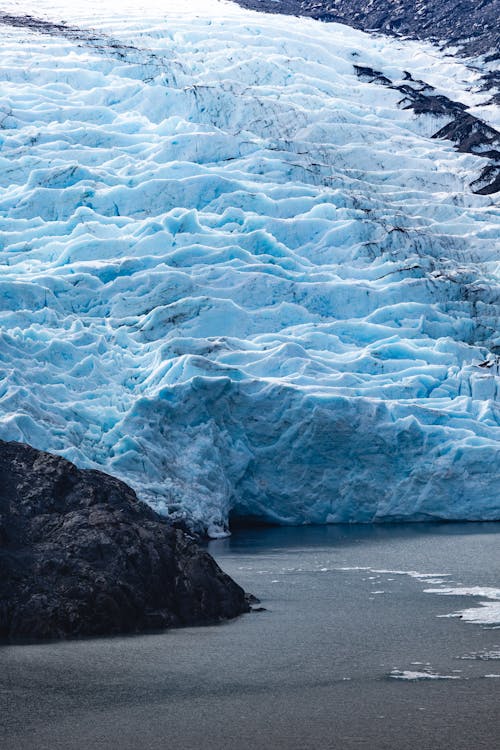 Free A large glacier with a large body of water Stock Photo